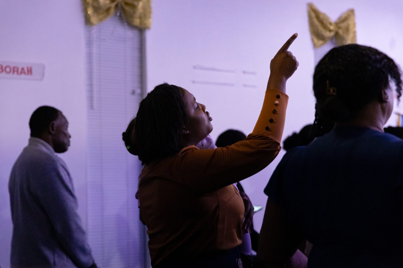 Congregation member pointing upward in worship