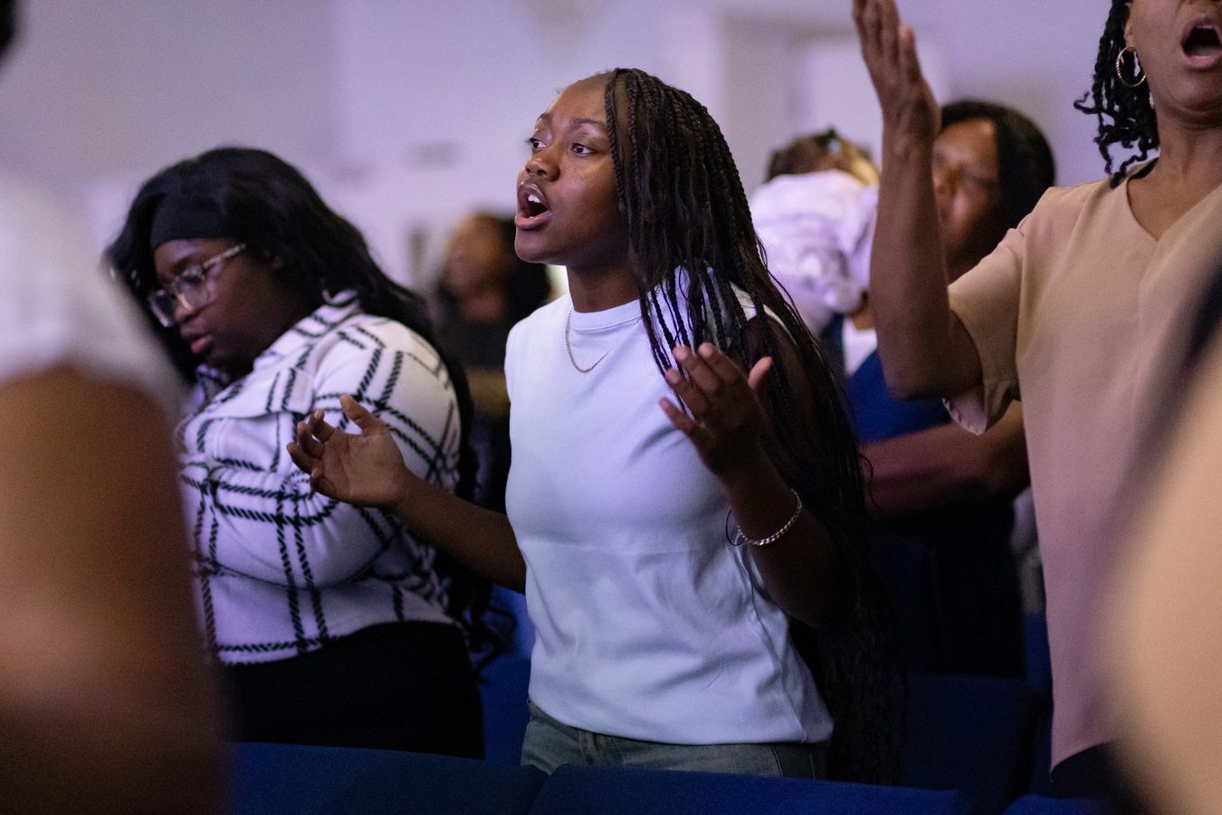 Young woman worshipping in congregation