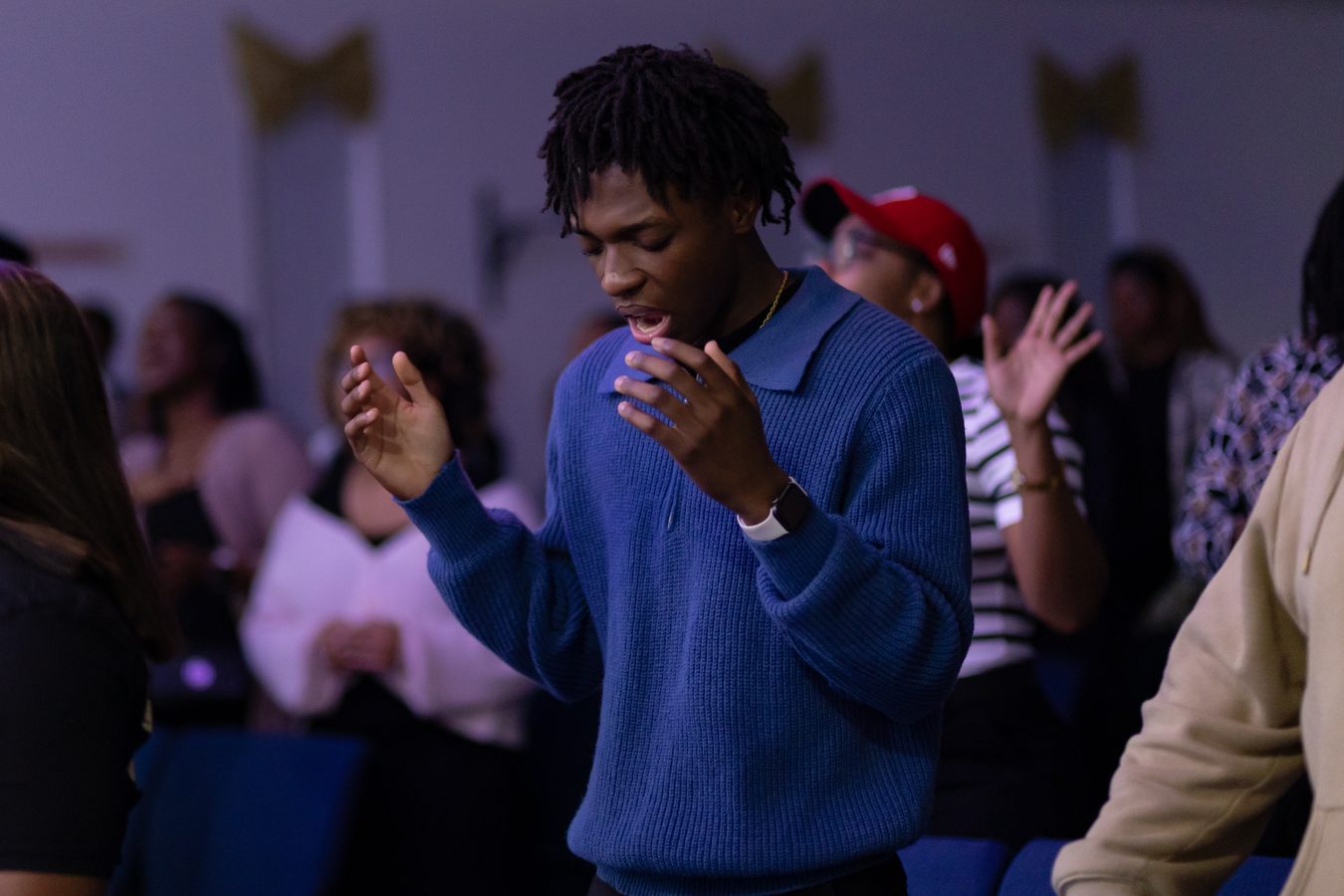 Young man worshipping in congregation